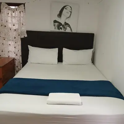 a bed with a blue and white blanket on it at Tripple S in Bellville