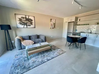 a living room with a couch and a table and a kitchen at 18 On 40 North in Cape Town