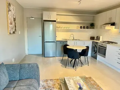 a kitchen with a table and chairs in a living room at 18 On 40 North in Cape Town