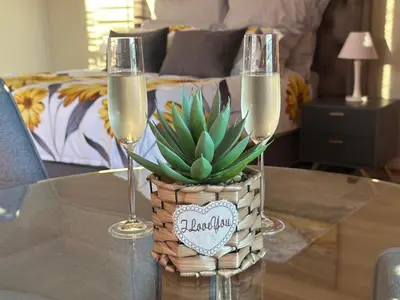 two champagne glasses and a potted plant on a table at Cape Golf Villa in Cape Town