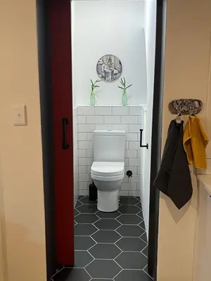 a bathroom with a toilet with two plants on the wall at Rocket Room in Stellenbosch