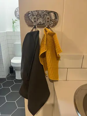 a bathroom with a sink and towels hanging on a counter at Rocket Room in Stellenbosch