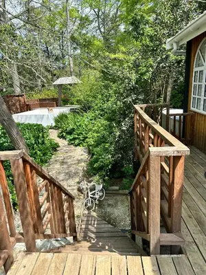 a wooden walkway leading to a deck with a bench at Rose Cottage, Elgin Grabouw in Grabouw