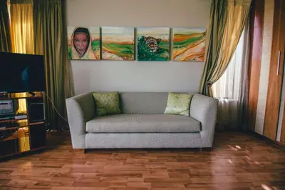 a living room with a couch and paintings on the wall at Castellon Boutique Hotel in Table View