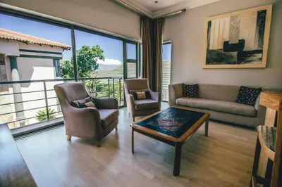 a living room with a couch and chairs and a table at Castellon Boutique Hotel in Table View