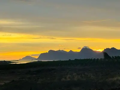 a sunset over the ocean with mountains in the background at Hermanus - Escape Wines - House on Wine & Protea farm in Lake Marina