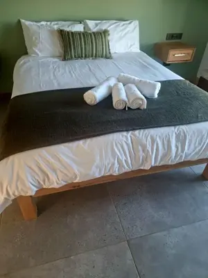 two rolled up towels sitting on a bed at Hermanus - Escape Wines - House on Wine & Protea farm in Lake Marina