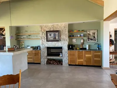 a kitchen with a stone fireplace in a room at Hermanus - Escape Wines - House on Wine & Protea farm in Lake Marina