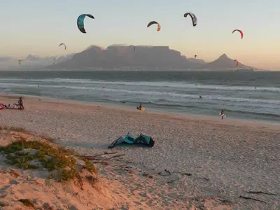 a group of people flying kites on a beach at Luxurious Ocean View Beachfront Apartment in Cape Town