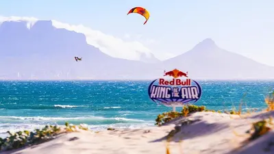 a red bull sign on the beach with a kite at Luxurious Ocean View Beachfront Apartment in Cape Town