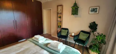 a room with two chairs and a table with towels at Tuinvrede Guesthouse in Welgemoed