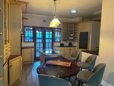 a kitchen with a wooden table and chairs at Suite Dreams Gorgeous Garden Holiday Home in Panorama