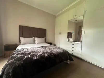 a bedroom with a large bed and a dresser at Suite Dreams Gorgeous Garden Holiday Home in Panorama