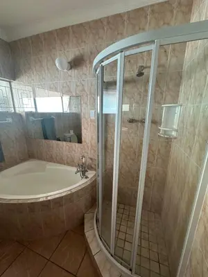 a bathroom with a shower and a tub and a sink at Suite Dreams Gorgeous Garden Holiday Home in Panorama