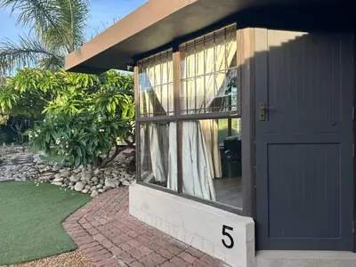 a house with a gray door with the number at Suite Dreams Garden Dream Cottage in Panorama