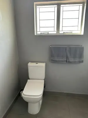 a bathroom with a white toilet and a window at Suite Dreams Garden Dream Cottage in Panorama