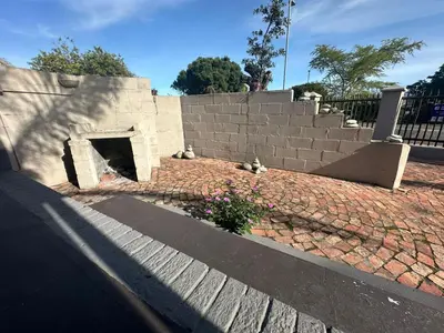 a brick retaining wall with a fireplace in a yard at Suite Dreams Spacious Apartment in Panorama