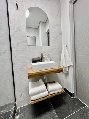 a bathroom with a sink and a mirror and towels at 34 On The Den in Stellenbosch