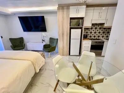 a bedroom with a bed and a table and chairs at 34 On The Den in Stellenbosch