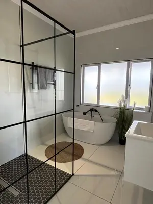 a bathroom with a shower and a tub and a sink at Jacana Lodge Zeekoevlei in Lotus River