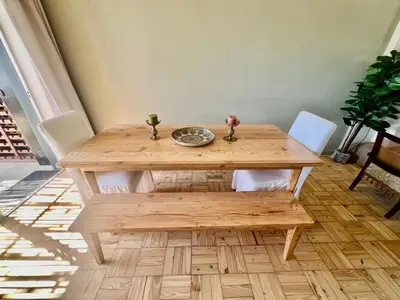 a wooden table with two chairs and a bowl on it at The House Next Door in Stellenbosch