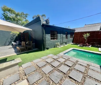 a backyard with a swimming pool and a house at The House Next Door in Stellenbosch