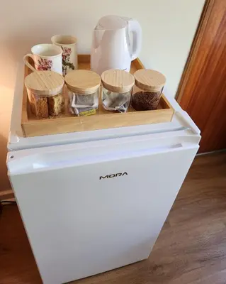 a white refrigerator with spices and cups on it at Cosy en-suite room Stellenbosch in Stellenbosch