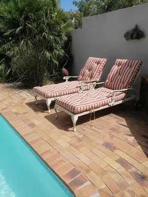 two lounge chairs sitting next to a swimming pool at Cosy en-suite room Stellenbosch in Stellenbosch