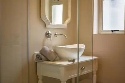 a bathroom with a sink and a mirror at 68 LErmitage Elegant Mountain Apartment in Franschhoek