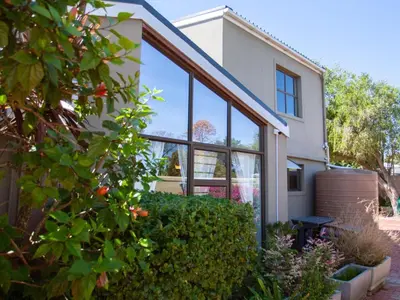 a house with large glass windows on the side of it at Julinas Guesthouse in Panorama