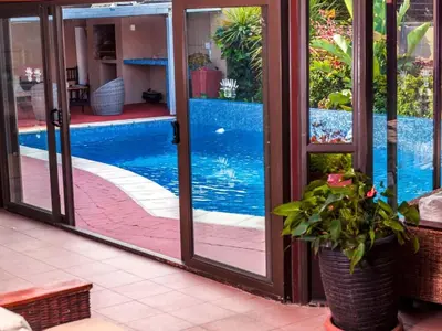 a pool seen through sliding glass doors with a potted plant at Julinas Guesthouse in Panorama