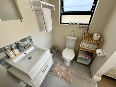 a bathroom with a sink and a toilet and a window at Little Haven in Kenridge