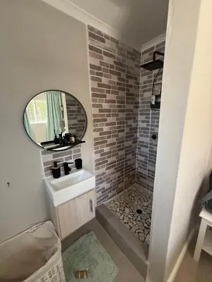 a bathroom with a sink and a mirror at Courtyard Hideaway in Kenridge