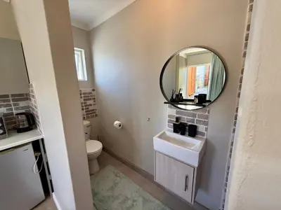 a bathroom with a sink and a mirror at Courtyard Hideaway in Kenridge