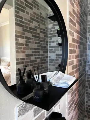 a bathroom with a black counter with a mirror at Courtyard Hideaway in Kenridge