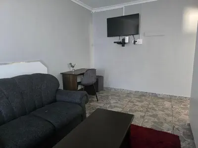 a living room with a couch and a table at Cozy home away from home in Cape Town