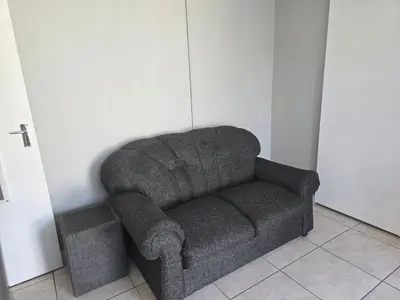 a gray couch in a corner of a room at Cozy home away from home in Cape Town