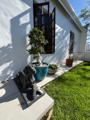 a statue of a dog sitting in front of a house at Helder Haven Cottage in Somerset West