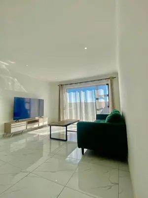 a living room with a couch and a tv at Chill & Cozy shared apartment with Michael in Cape Town