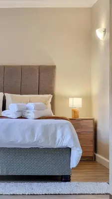 a bedroom with a large bed and a night stand at La Vita e Bella in Wellington