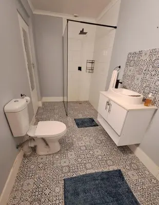 a bathroom with a toilet and a sink and a shower at Mooiloop Self Catering in Bellville
