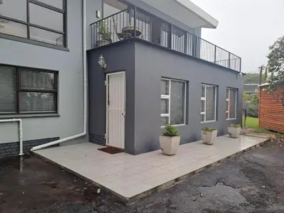 a blue house with two potted plants in front of it at Mooiloop Self Catering in Bellville