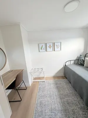 a bedroom with a bed and a table and a rug at Whale Melody Love Hermanus in Hermanus