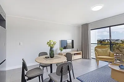 a living room with a table and chairs at Chic 1 bedroom apt in Century city in Cape Town