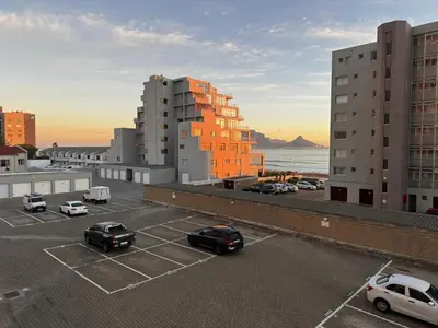 a parking lot with cars parked in a parking lot at SeeHUYS Boutique Bloubergstrand Beachfront Studio in Bloubergstrand