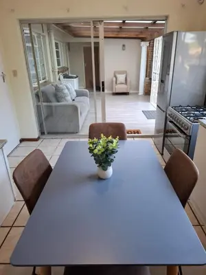 a dining room table with a vase of flowers on it at Chez Yves in Hoheizen