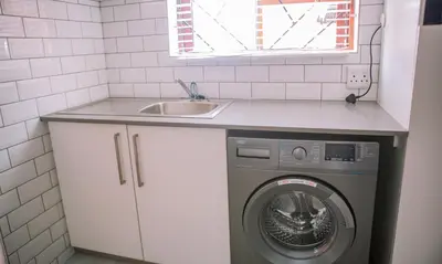 a kitchen with a washing machine and a sink at 26 on Balfour Crescent in Silver Sands