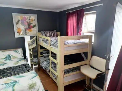 a bedroom with two bunk beds and a chair at 72 the trout lodge in Goodwood