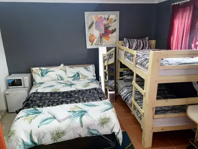 a bedroom with two bunk beds and a blue wall at 72 the trout lodge in Goodwood