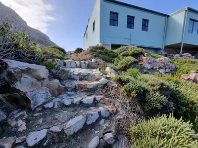 a house on top of a rocky hill at Thalassa in Bettyʼs Bay